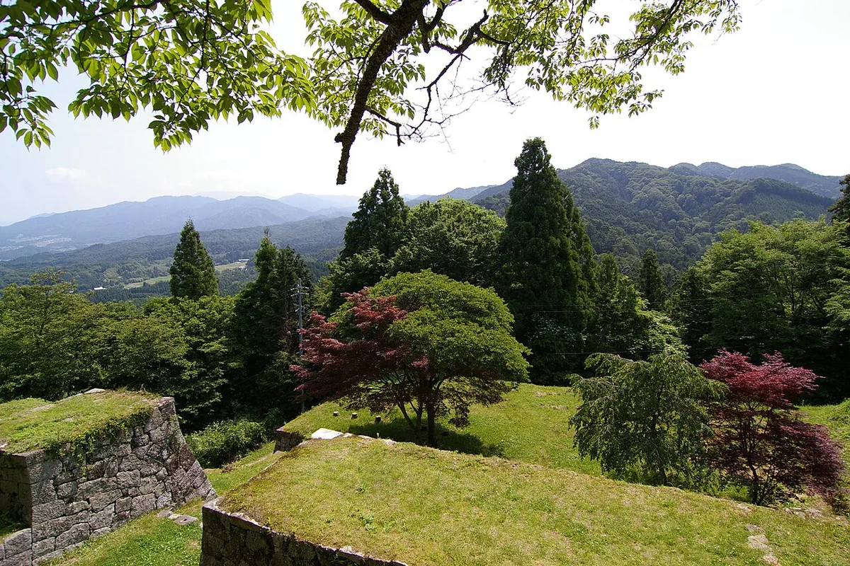 Stone walls and wooded hills at Iwamura Castle