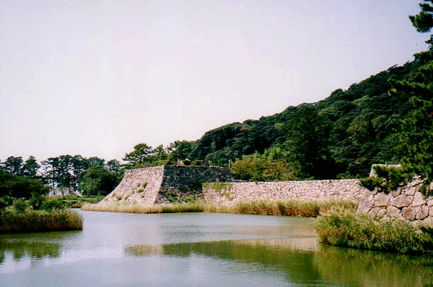 Moat and stone walls at Hagi Castle with Mount Shizuki behind