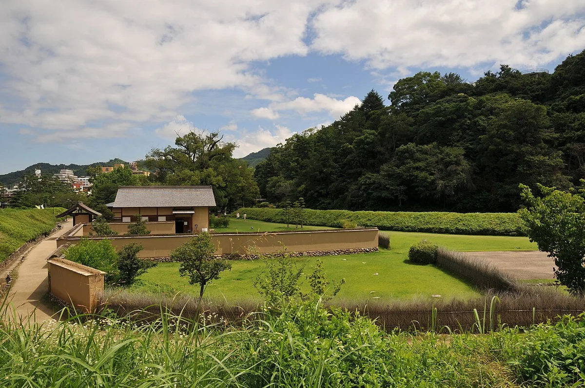 Grassy grounds and reconstructed buildings at Yuzuki Castle