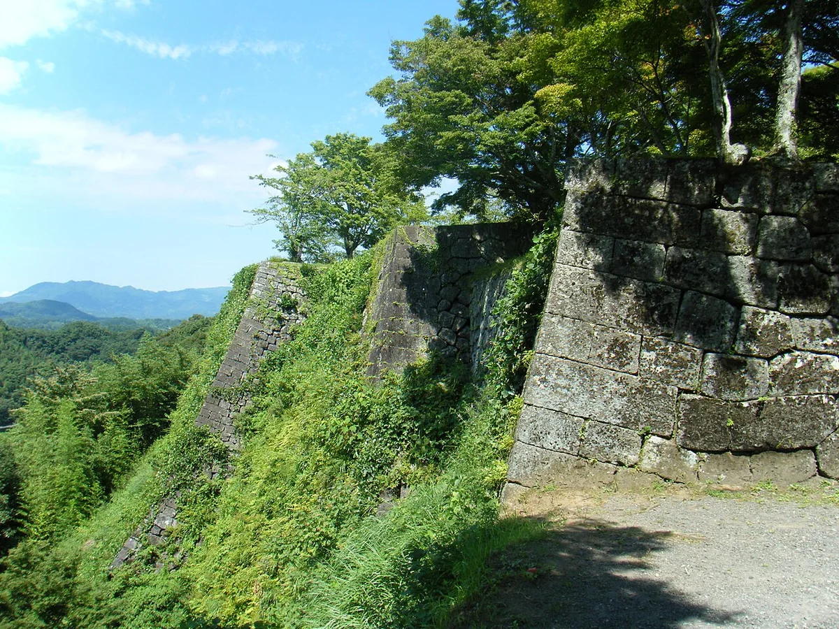 High stone walls following a steep slope at Oka Castle